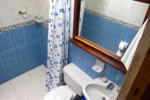 Baño de azulejos azules con aseo y lavamanos en El Almejal, en El Valle
