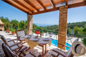 a patio with a table and chairs and a pool at Villa Elia, ,Platanos, Paxos in Koútsion
