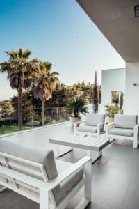 a living room with white furniture and palm trees at CASA DOS MARES in Tarifa +24 photos