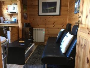 a living room with a black couch and a table at Dallymach pod in Lochboisdale +13 photos