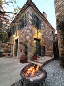 a fire pit in front of a stone house at Puli Stone Houses in Doğanbey