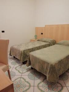 3 camas en una habitación con suelo de baldosa en Villa Giannina en Massa Lubrense
