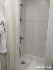 eine Dusche mit einem weißen Duschvorhang im Bad in der Unterkunft Hotel Paulina in Făleşti