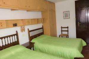 2 letti in una camera con lenzuola verdi di Casa Blascosanz - piso para 6 personas en el pirineo a Hecho