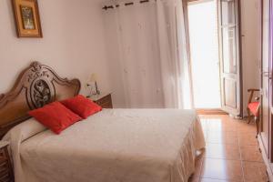- une chambre avec un lit doté de 2 oreillers rouges dans l'établissement Casa Blascosanz - piso para 6 personas en el pirineo, à Hecho