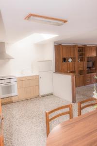 cocina con nevera blanca y armarios de madera en Casa Blascosanz - piso para 6 personas en el pirineo, en Hecho