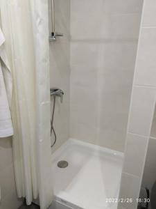 y baño con ducha blanca y cortina de ducha. en Hotel Paulina, en Făleşti