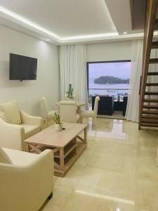 Una sala de estar con muebles blancos y vista al mar. en Hacienda Samana Bay Hotel, en Santa Bárbara de Samaná
