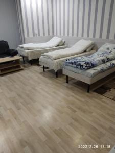 3 camas en una habitación con suelo de madera en Hotel Paulina, en Făleşti