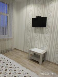 a room with a table and a tv on the wall at Hotel Paulina in Făleşti