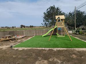 a playground with a slide on top of green grass at MAR Y MONTAÑA FORMENTERA in Sant Francesc Xavier