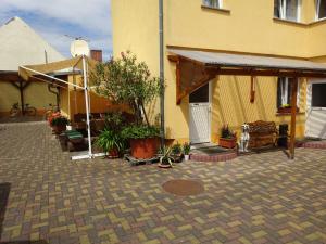 a yellow building with a patio with potted plants at Ferienwohnung Pension Sigwarth in Belgern +3 photos