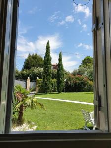 - une fenêtre donnant sur un jardin avec une pelouse dans l'établissement Villa Claudia, à Bardolino