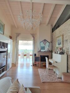 salon z żyrandolem, stołem i krzesłami w obiekcie Villa Claudia w mieście Bardolino