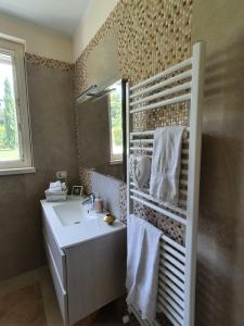y baño con lavabo blanco y espejo. en Villa Claudia, en Bardolino