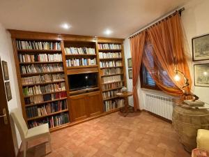 ein Wohnzimmer mit Bücherregalen mit Büchern in der Unterkunft Bellissima casa dentro il castello di San Savino in San Savino