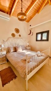 una camera con letto bianco e soffitto in legno di Ampelos Cretan Villa - Private Pool & Heated Ozone Jacuzzi a Yerolákkos