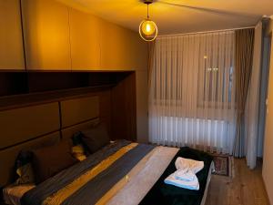 a bedroom with a bed in a room with a window at Elegant Apartment in City Centre in Pristina