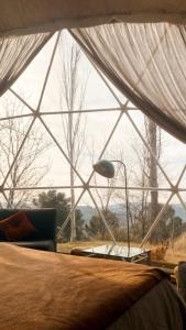 a bedroom with a bed and a large window at Camping Alpujarras in Laroles +45 photos