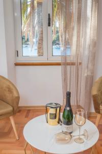 赫瓦爾的住宿－Deluxe Dreamy room in the Center of Hvar with Sea View，一张桌子,上面放着一瓶葡萄酒和两杯酒