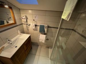 a bathroom with a sink and a shower at Hotel-Restaurant des Voyageurs in Le Cheylard