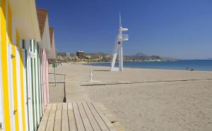 a beach with a light house and a lighthouse at 1ª linea del mar 2 habitaciones 2 baños, parking subterraneo incluido, mascotas in El Campello