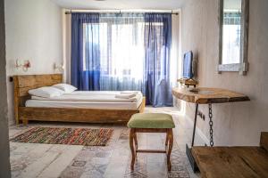 1 dormitorio con cama, mesa y ventana en Daulite boutique hotel en Rakovo