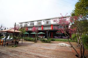 Sanyi Sakura Resort في ساني: مبنى بطابق خشبي امامه مقعد