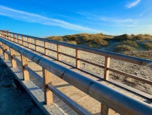 ノルトダイヒにあるAuszeit Norddeichの砂浜の木造遊歩道