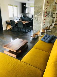 a living room with a yellow couch and a table at Baltic Sea Home in Jastrzębia Góra