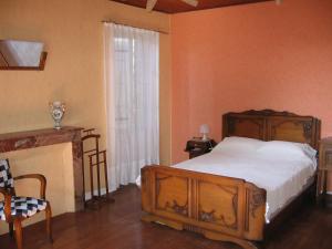 Panjas的住宿－Maison de campagne Les Chênes.，一间卧室设有一张木床和一个窗户。
