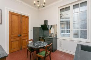 eine Küche mit einem Tisch und Stühlen sowie einem Fenster in der Unterkunft La Suite Napoléon 75m2 timeless stay in Béziers