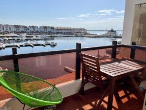 een balkon met een stoel en een tafel en uitzicht op een haven bij T2 sur Marina avec vue spectaculaire in Le Barcarès