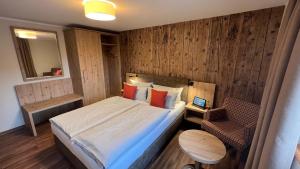 1 dormitorio pequeño con 1 cama y 1 silla en Dammschenke Gasthof & Hotel, en Kurort Jonsdorf