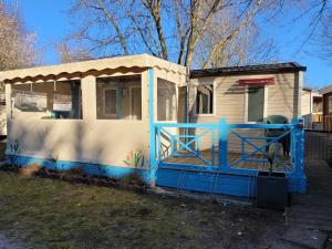 a blue and white house with a porch at Mobil Home Plage Lac Parentis/Biscarosse in Parentis-en-Born