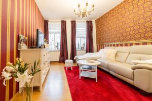 a living room with a couch and a red rug at Ferienwohnungen am Wintergarten in Gera