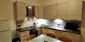 Una cocina con gabinetes blancos y una mesa con sillas. en Appartamento vista mare, en Tellaro 7 fotos más