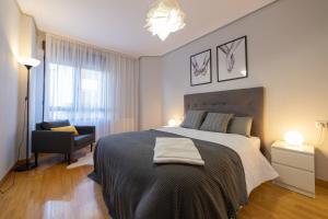 1 dormitorio con 1 cama grande y 1 silla en Apartamento Albelda Centro en Albelda de Iregua