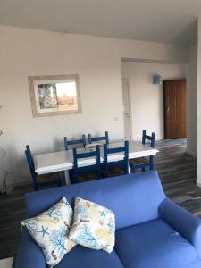 un soggiorno con un divano blu e un tavolo di Maison Turquoise a Cala Gonone