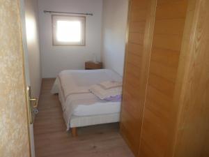 a small bedroom with a bed and a window at Villa du soleil levant in Apt