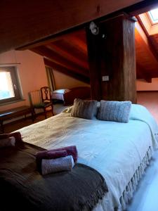 um quarto com uma cama grande com almofadas em La Maison de Joanna 2 em Châtillon