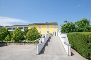 a yellow house with a staircase leading to a driveway at Pension Horvath jun. in Guntramsdorf