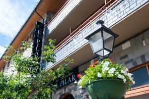 un semáforo y macetas de flores en el lateral de un edificio en El Pilar en Benasque