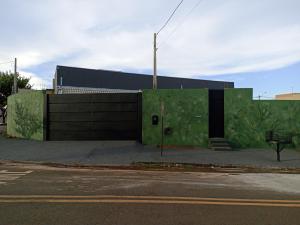a building with green paint on the side of it at Kitnets RECANTO MAGRO in Olímpia