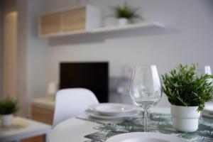 uma mesa com um copo de vinho e pratos em Apartamento Albelda Plaza em Albelda de Iregua