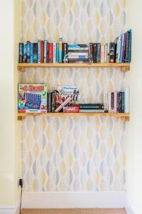 a book shelf filled with books on a wall at Fantastic, Spacious 3 Bedroom House With Garden in Bath