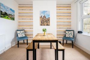 a table and two chairs in a room with striped walls at Fantastic, Spacious 3 Bedroom House With Garden in Bath