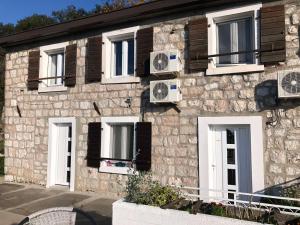 a stone building with white doors and windows at Family Stone house with magical Sea View in Kaluđerac