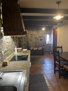 a kitchen with a stove and a table in a room at Casa da Aldeia in Azevo