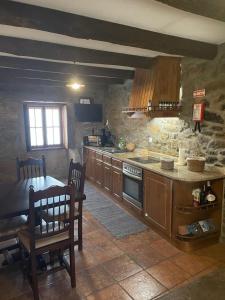 a kitchen with a table and a stove top oven at Casa da Aldeia in Azevo